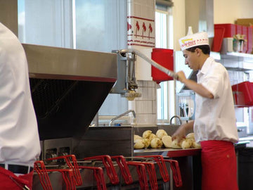 in n out workers working near a fryer