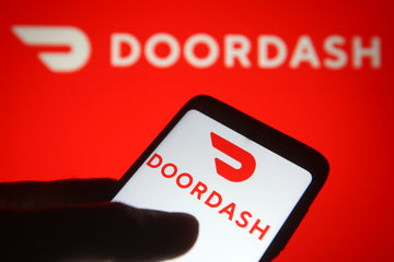 door dash logo on a phone screen with red door dash background