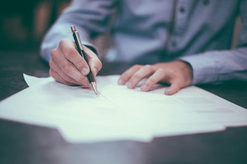 Restaurant owner reviewing stacks of insurance documents and invoices at a desk with a concerned expression