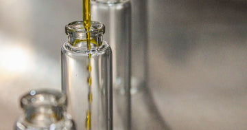 Clear glass bottle filled with golden yellow cooking oil — fresh frying oil appears visually similar to degraded oil, making color-based inspection an unreliable quality test